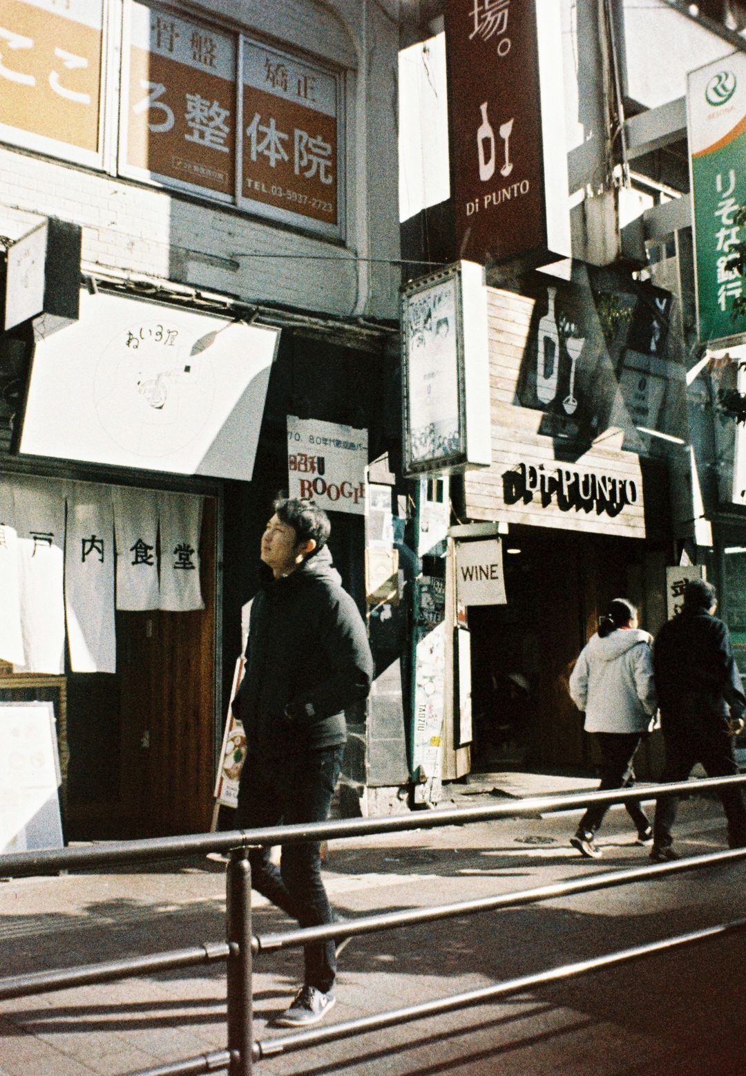 Sunlit street corner with shop signage