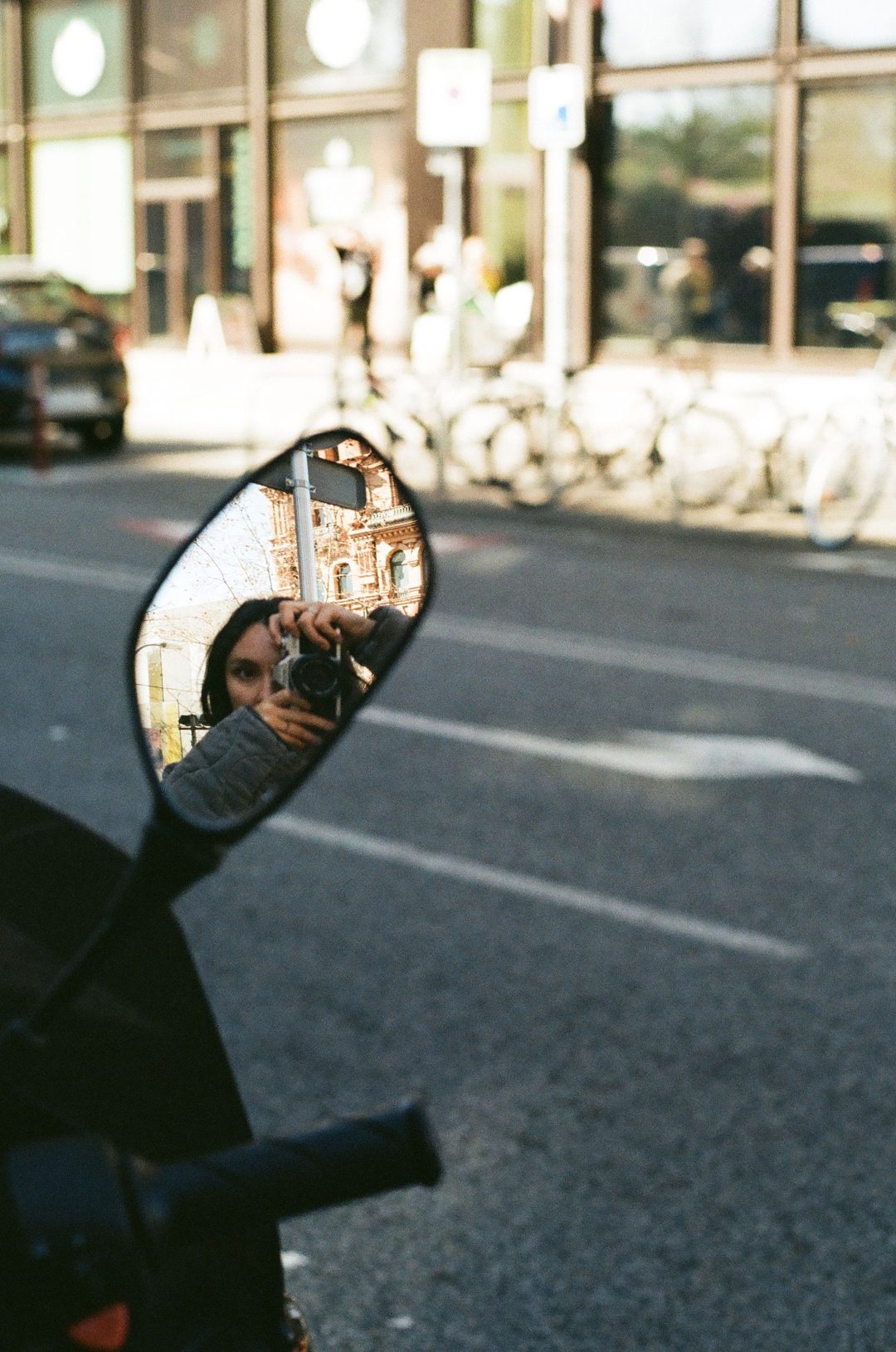 Street reflected in a motorbike wing mirror