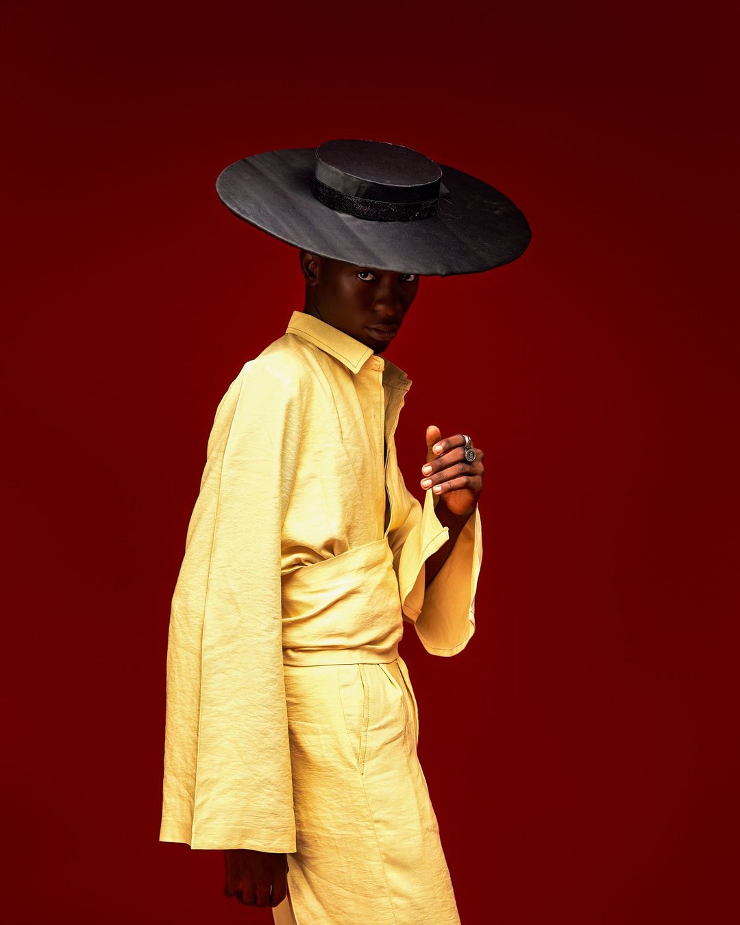 Figure in a yellow suit and wide-brim hat
