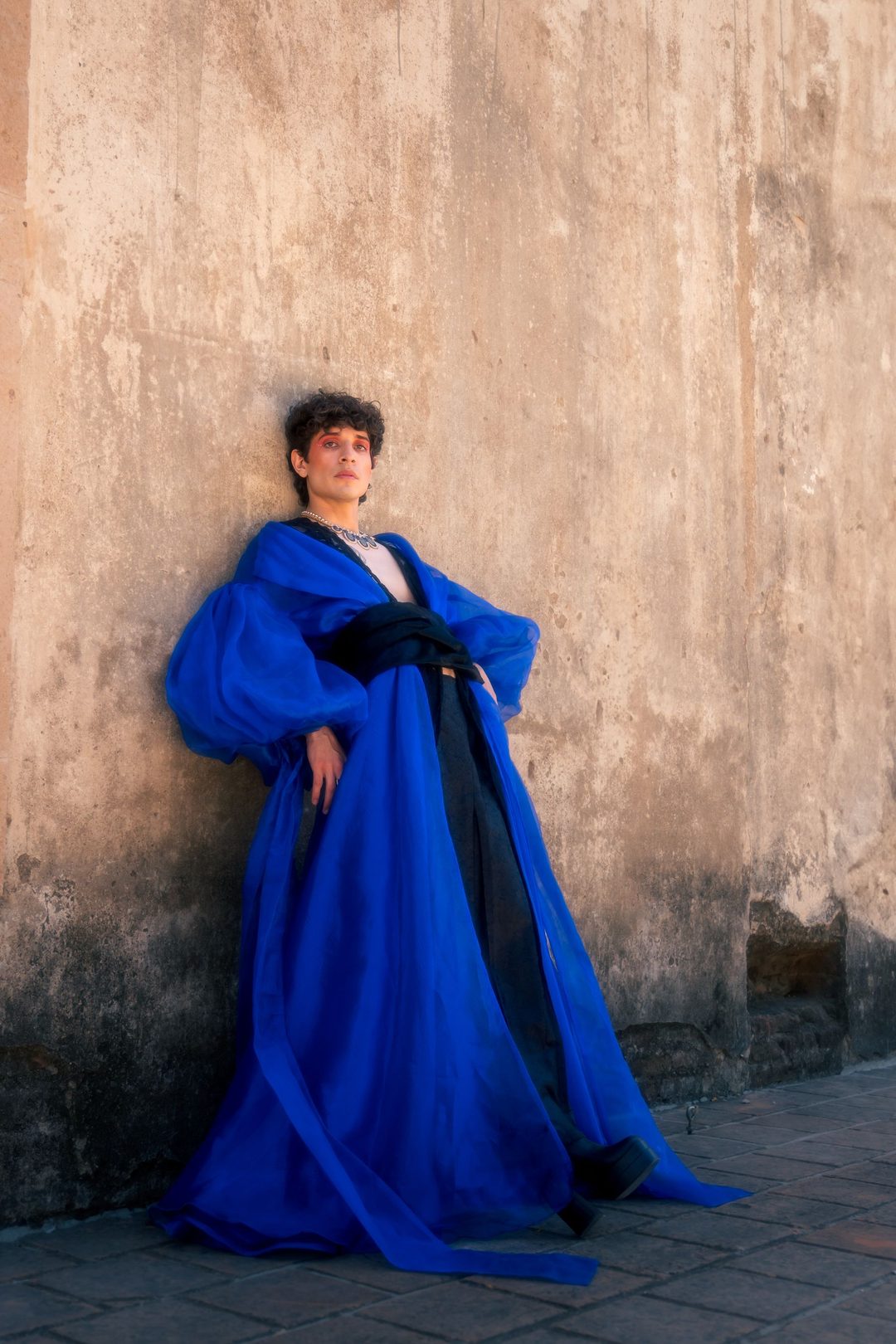 Cobalt blue coat against ochre wall
