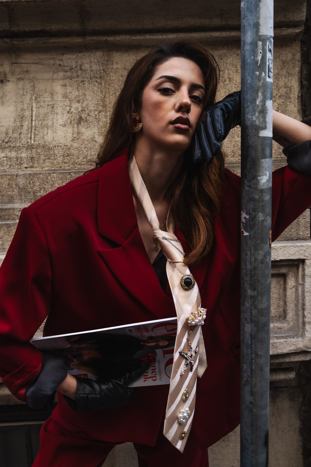Model seated on stone steps, jacket draped
